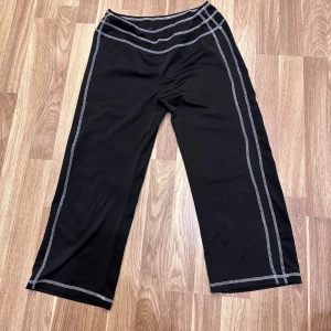 Svarta byxor med vita sömmar - Svarta byxor med vita kontrastsömmar. Storlek M