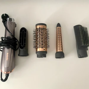 BaByliss hårstyler med tillbehör - Säljer en BaByliss hårstyler med flera tillbehör för olika stylingbehov. Setet inkluderar en hårtork, en rundborste med borst, en konformad locktång och en plattborste. Perfekt för att skapa volym, lockar eller släta frisyrer. Skriv innan du köper 😊
