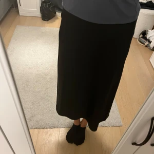 Svart kjol - Knappt använda svart kjol. Kjolen är typ en silkes tyg. Jättefin med dragkedja på sidan.