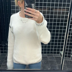 Vit stickad tröja från nelly  - Säljer en stickad tjöja med svarta detaljer från nelly, jag har använt den 3 gånger och säljer den för den för den är lite för stor för mig. Jag köpte den för 400 