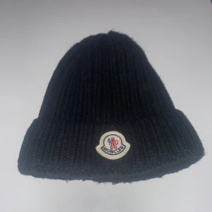 Moncler mössa  - Skön moncler mössa perfekt till vintern. Vet dock inte om den är äkta då den var en julklapp  7/10 skick