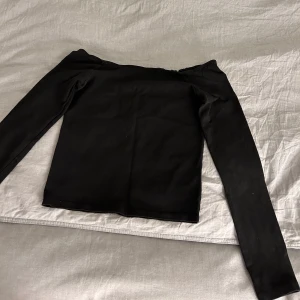 Svart långärmad tröja  - Svart off shoulder långärmad tröja som är använd men som är i god skick. Storleken är S.