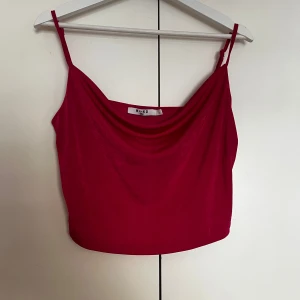 Rosa linnetopp från NA-KD - Säljer en snygg rosa linnetopp från NA-KD med tunna axelband och draperad halsringning. Perfekt för sommaren och enkel att matcha med både jeans och kjol.