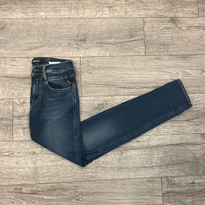 Blå Replay jeansbyxor - Säljer ett par klassiska blå jeans från Replay med raka ben och snygga slitningar. Jeansen har fem fickor, dragkedja och knapp i midjan. Perfekta för dig som gillar en tidlös stil med lite edge. | Storlek: 29/32 | Skick 8,5/10 | Hör gärna av dig vid fler frågor!