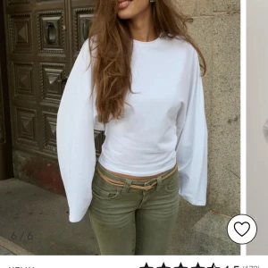 Vit långärmad topp med vida ärmar - Säljer en vit långärmad topp med riktigt vida ärmar och rund halsringning. Tröjan har en clean och stilren look, perfekt att styla med jeans eller kjol. Materialet känns mjukt och bekvämt mot huden.