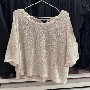 Vit stickad oversized tröja från H&M - Säljer en vit stickad tröja från H&M med lös och oversized passform. Tröjan har trekvartsärm och är perfekt för lager-på-lager. Mjuk och luftig struktur som ger en avslappnad look.