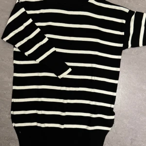 Svart och vit randig stickad tröja - Säljer en svart stickad tröja med vita horisontella ränder från SHEIN. Tröjan har lång ärm och rund halsringning. Perfekt för dig som gillar klassiska mönster och enkel stil. Även slits vid slutet. Aldrig använd. Kan sälja billigare!💕