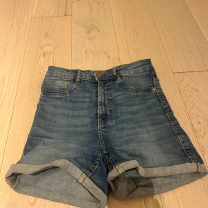 Blå jeansshorts från Gina Tricot - Säljer ett par klassiska blå jeansshorts från Gina Tricot, perfect jeans, i modellen ’MOLLY’. De har normal passform, uppvikta benslut och femficksdesign. De är highwaist, i storlek S. Perfekta för sommaren och lätta att matcha med olika toppar.🤩