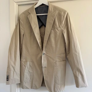 Oscar Jacobsson Kavaj - Beige bomullskavaj från Oscar Jacobsson. Ett riktigt måste inför sommaren!! Size 48, 8,5/10.
