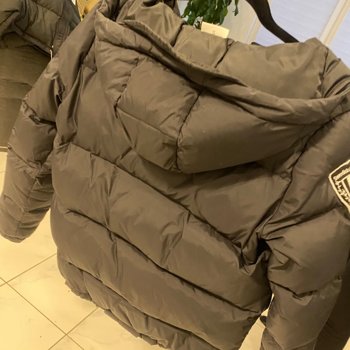 Svart pufferjacka med huva och patch - 2