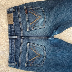 Blå bootcut jeans från VILA - ‼️läs hela‼️Säljer ett par skitsnygga jeans från vila, beställde hem dem och dem var väldigt för små. Eftersom att jag inte får på mig dem kan jag tyvärr inte skicka bilder med dem på. Men dem är lågmidjade och bootcut. ⚠️ som ni ser har dem slitningar i skrevet, inte så tydliga. Det är nog lätt att sy ihop. Midjemått: 36 innerbenslängd: 75 (passar nog dig som är runt 163 cm). Skriv vid funderingar och frågor💕💕