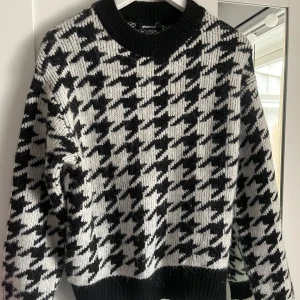 Svartvit stickad tröja med hundtandsmönster - Säljer en stickad tröja från Gina Tricot i svart och vitt med klassiskt hundtandsmönster. Tröjan har rund halsringning, långa ärmar och ribbade muddar vid ärmslut och nederkant. Perfekt för kyligare dagar! Använd få gånger. Skriv för fler bilder💞