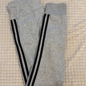Grå mjukisbyxor från Adidas XS - Grå mjukisbyxor från Adidas. Byxorna har resår och snörning i midjan samt muddar vid bensluten. Säljer pga för små då jag ej använt på flera år. Inga defekter. 