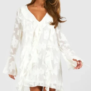 Vit volangklänning med v-ringning - Säljer för att den tyvärr inte har kommit till användning! Använd endast 1 gång på min Konformation, Superfin vit kortklänning med v-ringning och volangdetaljer framtill. Klänningen har långa ärmar med knyt vid ärmslut och ett lätt transparent tyg med struktur. Perfekt för sommarens alla tillfällen!