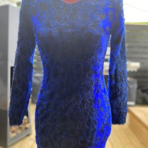 Blå leopardmönstrad fluffig klänning S - Denna iögonfallande klänning har ett djärvt blått och svart leopardmönster. Den har långa ärmar och en smickrande V-ringning, vilket gör den till ett perfekt val för en utekväll eller ett speciellt tillfälle. Längd: 75 cm, Bystvidd: 42 cm ﻿Uppskattad storlek S ﻿Mycket bra skick!   Inga bilder när den sitter på mig! Katter finns i hemmet!