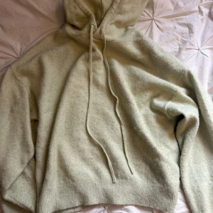 Beige stickad hoodie från Lindex XS - Mysig beige stickad hoodie från Lindex i storlek XS. Tröjan har huva med snörning, ribbade muddar och en loose passform. Perfekt för kyliga dagar när du vill vara både bekväm och snygg.
