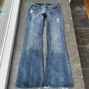 Lågmidjade bootcut jeans -  så fina 7 for all mankind low waist bootcut jeans med slitningar. Helt perfekta men tyvärr blivit för små för mig.  Midja 38cm, innerben 83cm. 