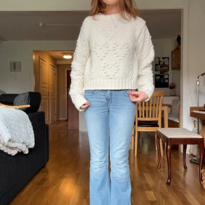 Vit stickad tröja med hjärtmönster Monki - Supermysig vit stickad tröja från Monki med hjärtmönster framtill. Tröjan har en loose passform, ribbade muddar och rund hals. Perfekt för kyliga dagar och ger en söt vibe till din outfit.