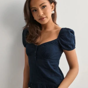 Mörkblå blus med puffärmar - Somrig mörkblå topp med knappar. Toppen är aldrig använd och är i perfekt skick 