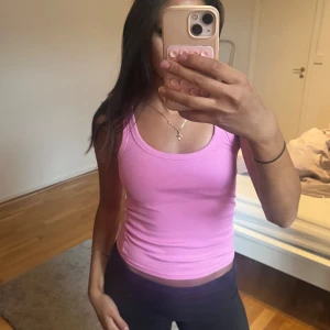 Ribbad rosa linnetopp - Säljer en ribbad rosa linnetopp med rund halsringning och croppad passform. Perfekt för dig som gillar en enkel men snygg stil. Toppens material är mjukt och stretchigt, vilket gör den superbekväm att bära hela dagen.