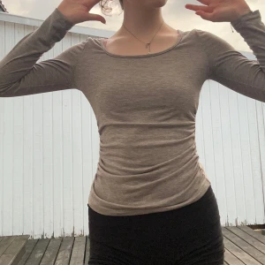 Beige långärmad topp i bomull - En simpel grå figursydd långärmad i en grå färg, ser mer grå ut i verkligheten, får fram kroppens figurer super snyggt!