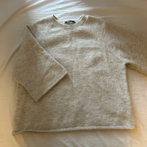 Beige stickad tröja från Gina Tricot - Mysig beige stickad tröja från Gina Tricot i storlek S. Tröjan har en rak passform, rund halsringning och trekvartsärmar. Perfekt för lager-på-lager och chill höst- och vinterdagar. Enkel och stilren design som funkar till allt.