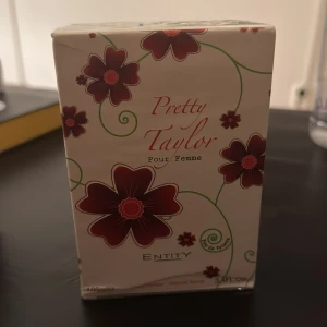 Pretty Taylor Pour Femme parfym - Pretty Taylor Pour Femme från Entity är en Eau de Toilette. För dig som gillar blommiga och fräscha dofter. Flaskan rymmer 100 ml. Helt ny och oöppnad förpackning