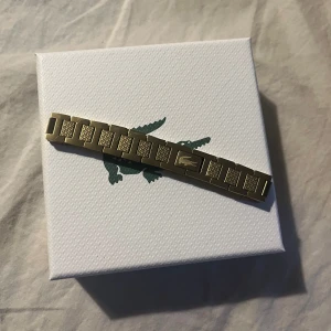 Guldigt armband från Lacoste - Säljer nu mitt guld armband från Lacoste knappt använd, köpte den för ett halv år sedan för 1100kr.