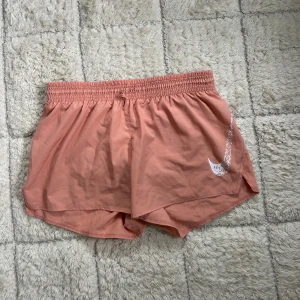 Nike rosa träningsshorts - Snygga rosa träningsshorts från Nike med elastisk midja, lätta och luftiga i Dri-FIT-material som andas, perfekta för löpning eller gym