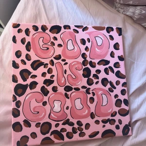 God is Good - Färgstark och trendig tavla med texten 'God is Good' i stora, bubbliga bokstäver mot en rosa bakgrund med leopardmönster. Perfekt för dig som vill ha en unik och inspirerande inredningsdetalj med popkänsla. Den är inte köpt utan handgjord av mig😊