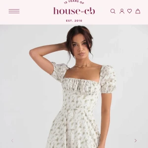 NY HOUSE OF CB KLÄNNING  - Superfin och oanvänd långklänning från House of CB i vit med små blommiga mönster. Klänningen har puffiga kortärmar, markerad midja och fyrkantig urringning. Perfekt för sommarens alla tillfällen och ger en romantisk vibe. Har prislappen fortfarande på. Ursprungspris 1800 kr 