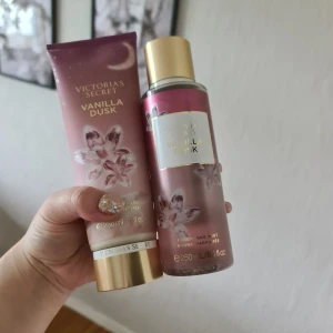Victoria's Secret Vanilla Dusk set - Säljer ett set med Vanilla Dusk body lotion och fragrance mist från Victoria's Secret. Båda har en lyxig lila-rosa design med guldiga detaljer och blommotiv. Doften har inslag av rik vanilj, citrusnektar och saftig plommon. Perfekt för dig som älskar söta och fruktiga dofter. Helt nytt och oanvänt. Säljer endast via köp nu inga förhandlingar 