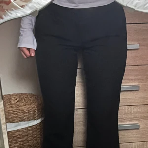 Svarta kostymbyxor med bootcut - Säljer ett par svarta kostymbyxor från Bik Bok med bootcut-snitt. Byxorna har medelhög midja, hällor för bälte och klassiska fickor fram. Perfekta för en clean och stilren look. Materialet är mjukt och följsamt, vilket gör dem riktigt sköna att bära.