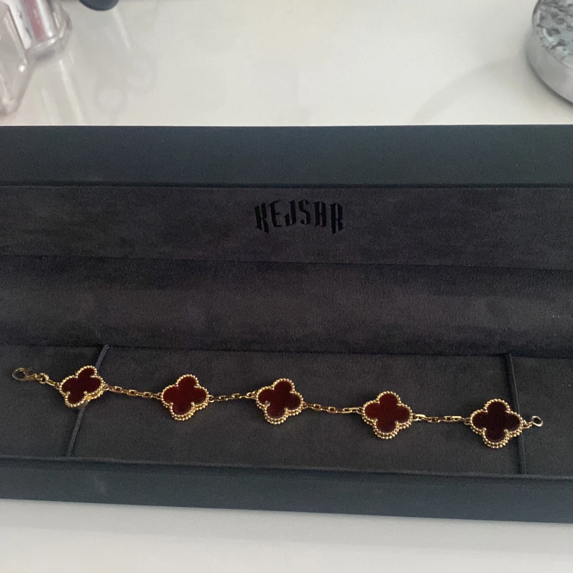 Guldigt armband med röda klöver från Kejsar