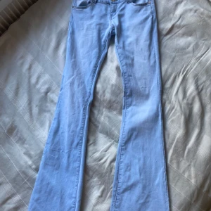 Ljusblå bootcut jeans - Säljer ett par ljusblå jeans med bootcut-snitt. Byxorna har klassisk femficksdesign och är tillverkade i mjukt jeanstyg. Perfekta för dig som gillar en retro vibe och vill ha ett par jeans som sticker ut lite extra.