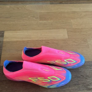 Adidas F50 - Säljer ett par Adidas F50 fotbollsskor i en riktigt fet rosa färg med blå och gula detaljer.  Säljer pga att dem är för små för mig. Nypris 3000kr