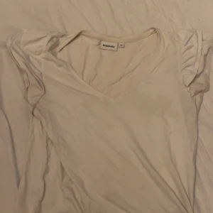 t shirt - Enkel och stilren vit topp från Kappahl med v-ringning och korta ärmar med lite volanger. 