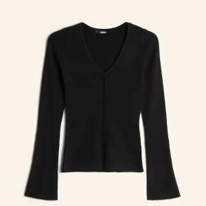Svart ribbad v-ringad tröja BikBok - Svart långärmad tröja från BikBok med v-ringning och ribbad struktur. Tröjan har en snygg slits framtill och sitter figurnära utan att vara för tight. Perfekt till jeans eller kjol för en clean look.