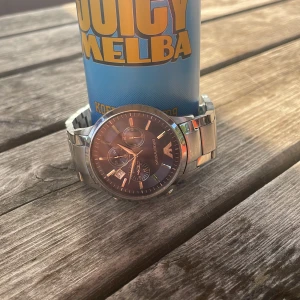 Emporio Armani silverklocka blå urtavla - Stilren klocka från Emporio Armani med silverfärgad länk i rostfritt stål och mörkblå urtavla. Klockan har tre mindre urtavlor, datumvisning och klassisk logga upptill. Perfekt accessoar för dig som gillar snygga detaljer och modern design.