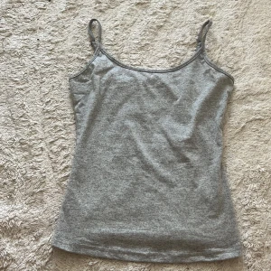 Grå linnetopp från SHEIN XS - En enkel och stilren grå linnetopp från SHEIN i storlek XS. Toppen har smala axelband och är tillverkad i mjuk polyesterblandning. Perfekt att matcha med jeans eller kjol för en clean look.