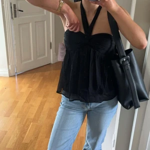 Svart halterneck topp från Nelly - Supersnygg svart  topp från Nelly som är använd en gång🥰