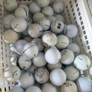 50 övningsbollar dessa bollar är inte i ett tillräckligt skick för att kunna vara i våran A,B,C klass - Bilden visar en korg fylld med begagnade golfbollar.