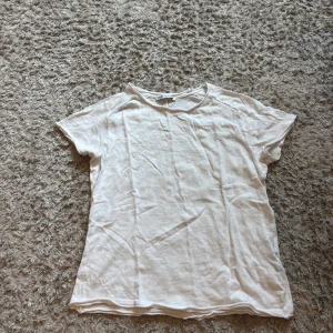 Vit basic t-shirt från Zara - Enkel och stilren vit t-shirt från Zara i mjuk bomull. Modellen är klassisk med rund halsringning och korta armar, den har liven en söm längs med ryggen som en detalj