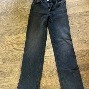 Svarta raka jeans från Zara - Svarta jeans från Zara i storlek 34. Klassisk femficksmodell med raka ben och normal passform. Jeansen har en snygg tvättad look och är tillverkade i bomullsmix för en skön känsla. Perfekta till sneakers eller boots.