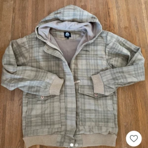 Beige rutig hoodiejacka  - Säljer en beige rutig hoodiejacka från Matix i storlek M. Jackan har huva, dragkedja och knappar framtill samt två fickor med lock. Muddar vid ärmslut och nederkant. Perfekt för svalare dagar. Skicka ett meddelande för frågor, mått, osv