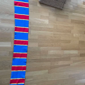 Randig Djurgården halsduk i blått och rött - Säljer en djurgården halsduk i nyskick då den var till för en samling av halsdukar som jag nu säljer av, säljs för halva inköpspriset!