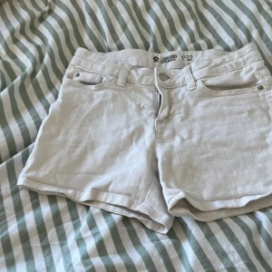Vita jeansshorts med dragkedja - Snygga vita jeansshorts från Cubus med klassisk femficksdesign, bälteshällor och dragkedja framtill. Perfekta för varma dagar och enkla att matcha med olika toppar.