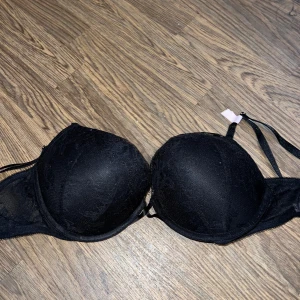 Victoria secret Svart push-up bh med spetsdetaljer - Säljer en svart pushup-bh från vs, strl 38C (amerikansk strl) alltså 85C. Helt oanvänd och lappen finns kvar!