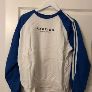 Vit och blå sweatshirt från Kaotiko - Säljer en vit sweatshirt med blå ärmar från Kaotiko. Storlek S