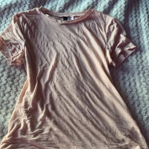 Ljusrosa t-shirt från H&M - En enkel och stilren ljusrosa t-shirt från H&M. T-shirten har rund halsringning och korta ärmar. Tillverkad i mjuk bomull som känns skön mot huden. Perfekt basplagg att matcha med jeans eller kjol. lite mer genomskinlig men sitter väldigt fint ändå🩷 inköpt för ca 100 kr använd fåtal gånger (ganska dåliga bilder den ser bättre ut på)